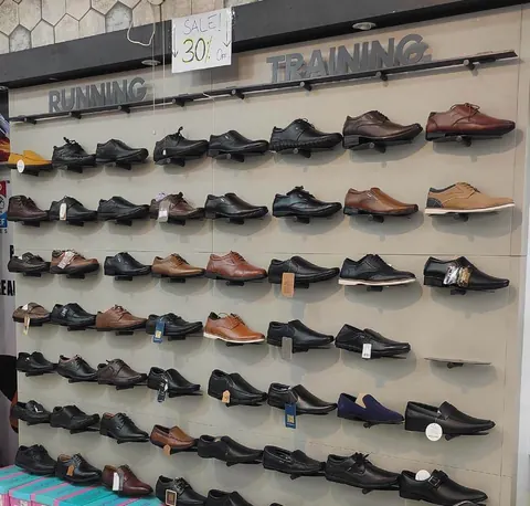 Wall of men's formal shoes beside the running shoe section